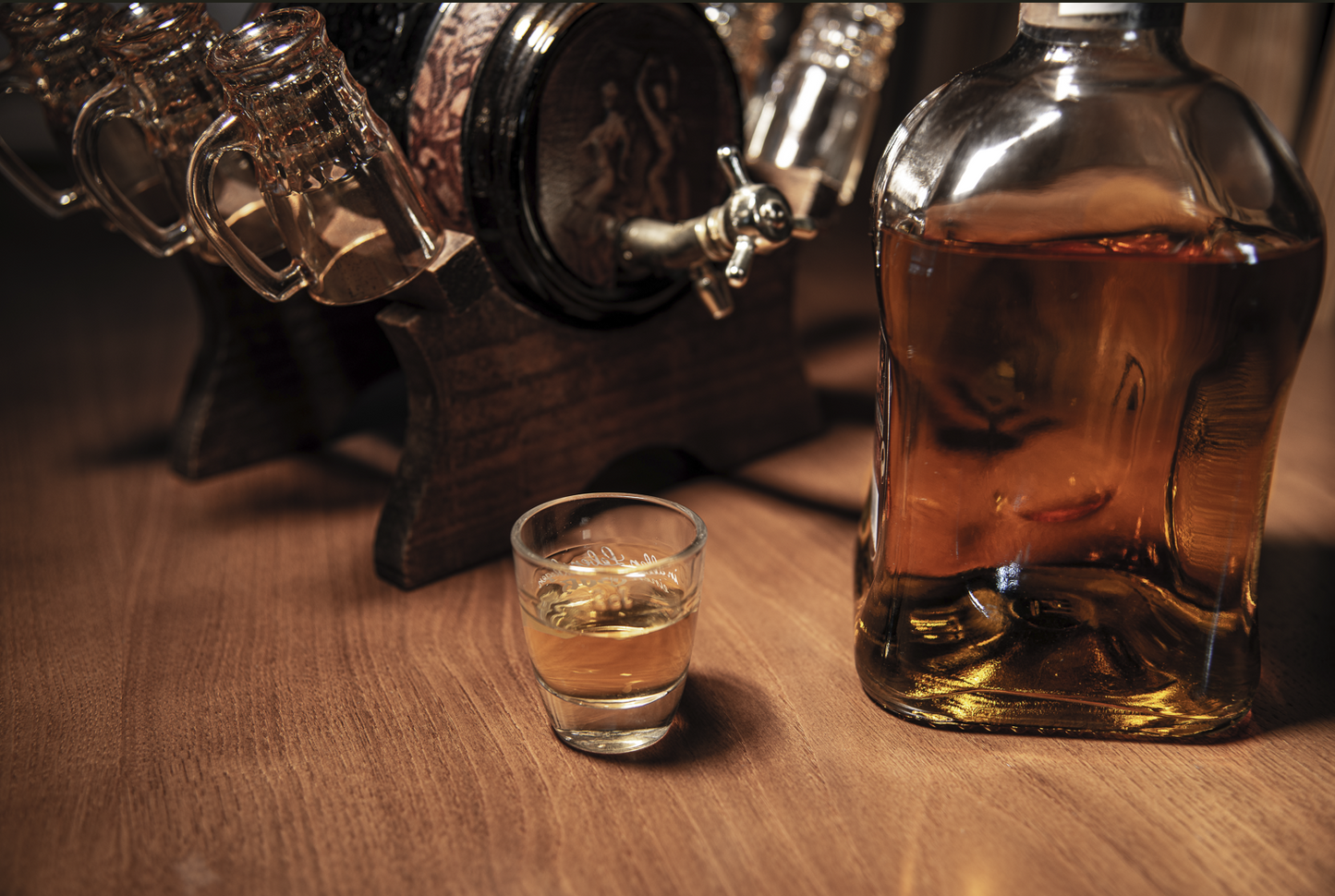 Whiskey bottle and shot glass on a wooden surface with a bar setup in the background.