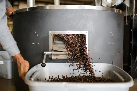 Coffee beans waterfalling into a bin after roasting