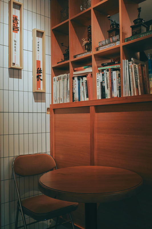 Cozy corner with a simple wooden chair and table, next to the book shelf, a perfect spot for coffee