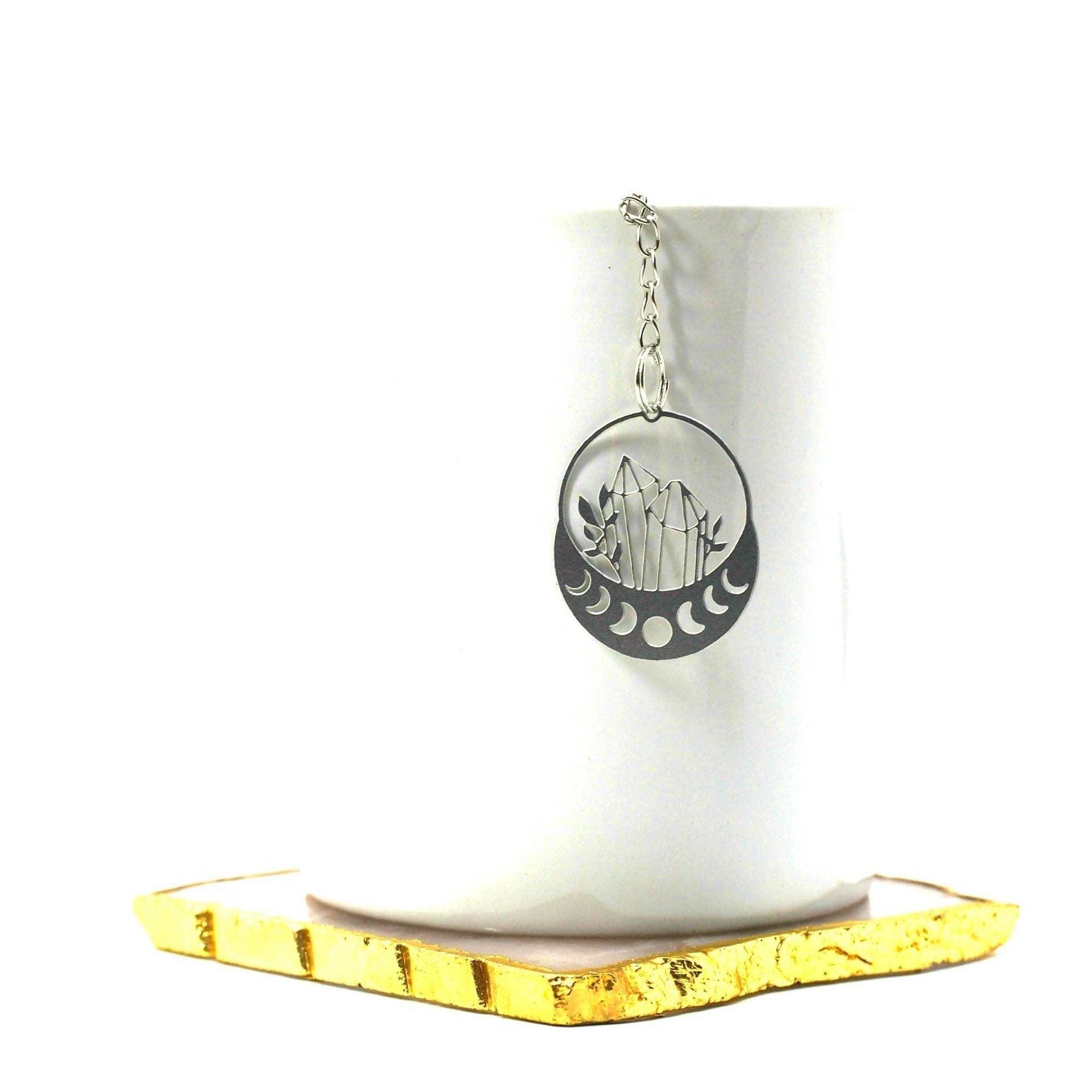 Necklace with a circular pendant on a white cup with a gold base