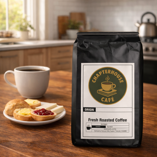 Black coffee bag with a label on a wooden table in a kitchen setting